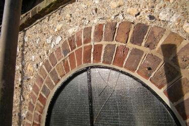 Photograph showing arched brickwork around a window after repair. Photograph showing arched brickwork around a window after repair.