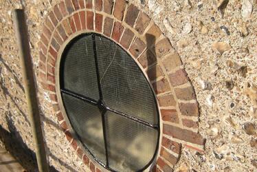 Photograph showing arched brickwork around a window after repair. Photograph showing arched brickwork around a window after repair.