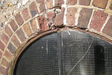 Photograph showing arched brickwork around a window needing repair. Photograph showing arched brickwork around a window needing repair.