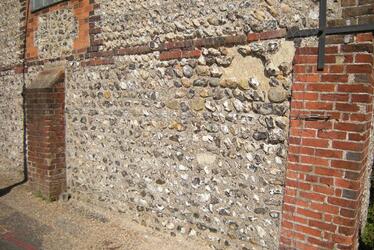 Photograph showing flintwork before renovation works began. Photograph showing flintwork before renovation works began.